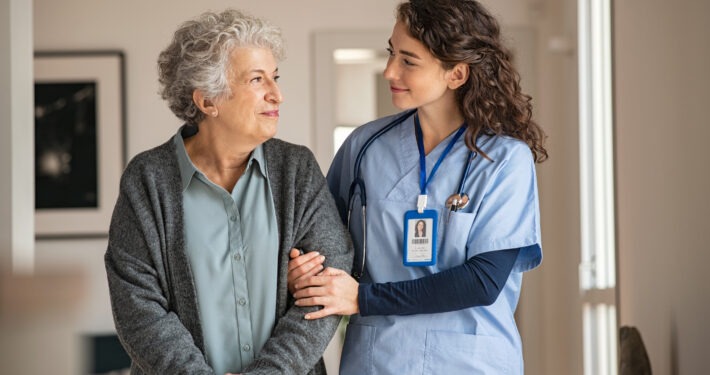 Caregiver assist senior woman at home